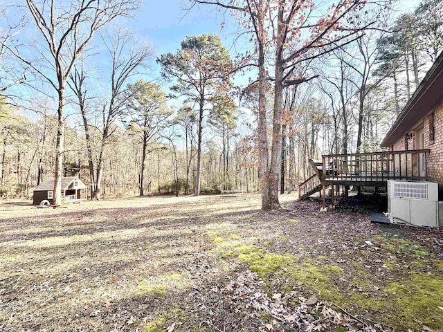 view of yard featuring an outdoor structure, a wooden deck, and stairs