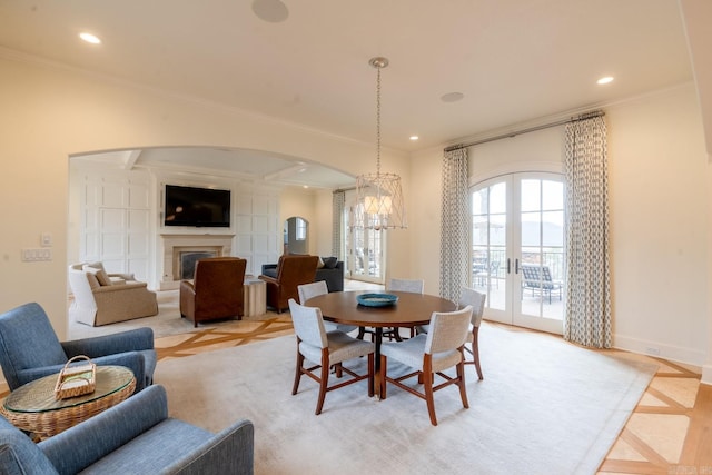 dining space with arched walkways, recessed lighting, a fireplace, french doors, and ornamental molding