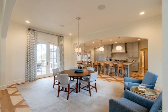 dining room featuring arched walkways, french doors, ornamental molding, and recessed lighting