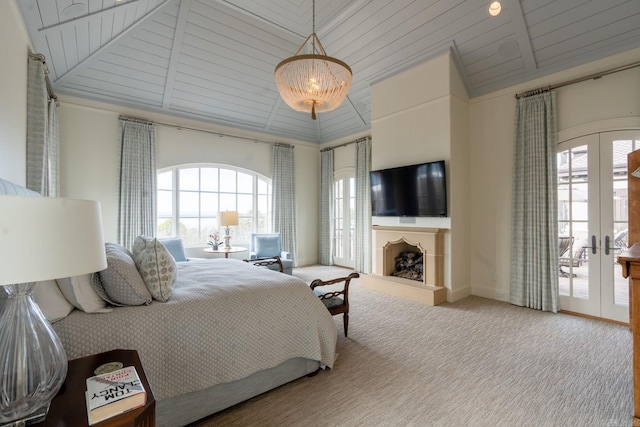 bedroom featuring a fireplace with raised hearth, access to outside, carpet flooring, french doors, and high vaulted ceiling