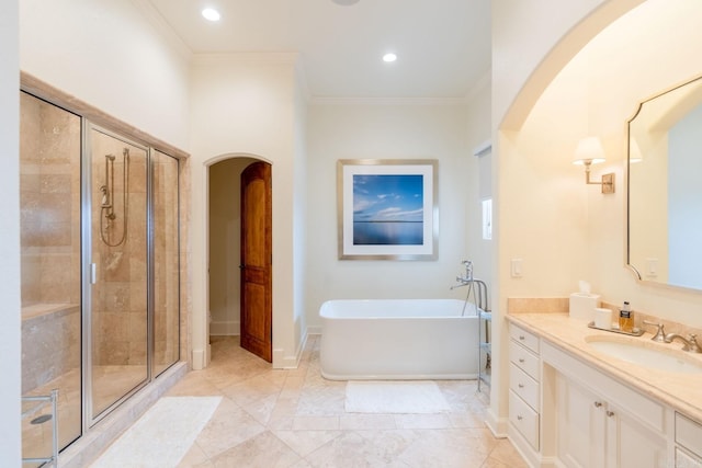 bathroom featuring a stall shower, a freestanding tub, crown molding, and vanity