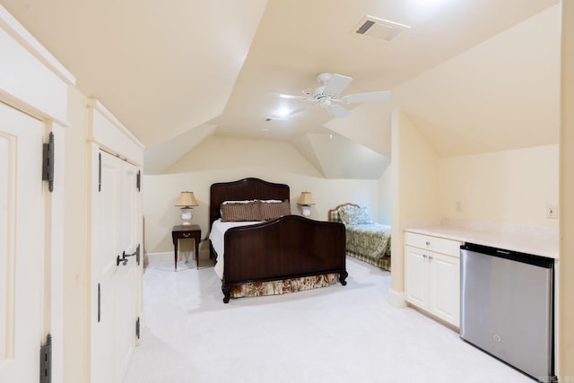 bedroom featuring refrigerator, lofted ceiling, visible vents, light carpet, and ceiling fan