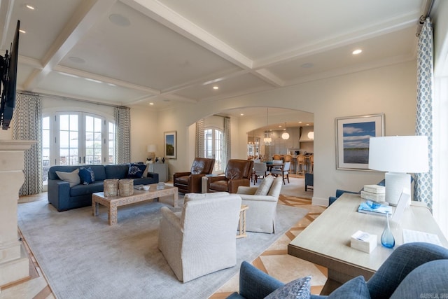 living area with arched walkways, coffered ceiling, a wealth of natural light, and french doors