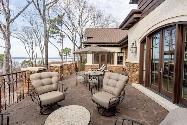 view of patio / terrace featuring french doors and a water view