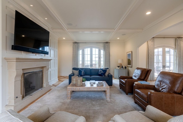 living area with arched walkways, french doors, a fireplace with raised hearth, coffered ceiling, and beamed ceiling