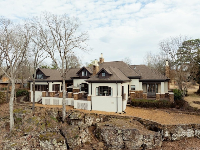 view of front of property with a chimney and stucco siding