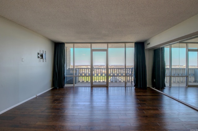 spare room with baseboards, a textured ceiling, floor to ceiling windows, and dark wood-type flooring