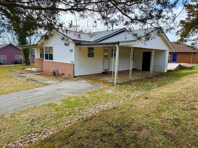 view of front of home featuring a carport, driveway, a front lawn, and brick siding