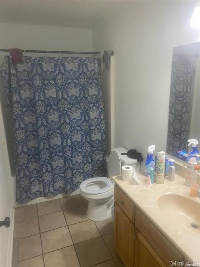 bathroom featuring vanity, a shower with shower curtain, tile patterned flooring, and toilet