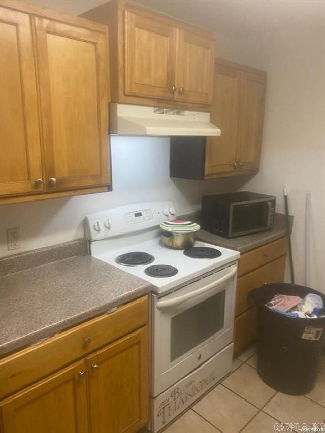 kitchen with light tile patterned floors, white range with electric stovetop, and under cabinet range hood