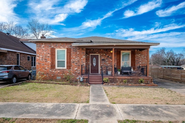 bungalow-style house featuring covered porch, brick siding, fence, crawl space, and a front lawn