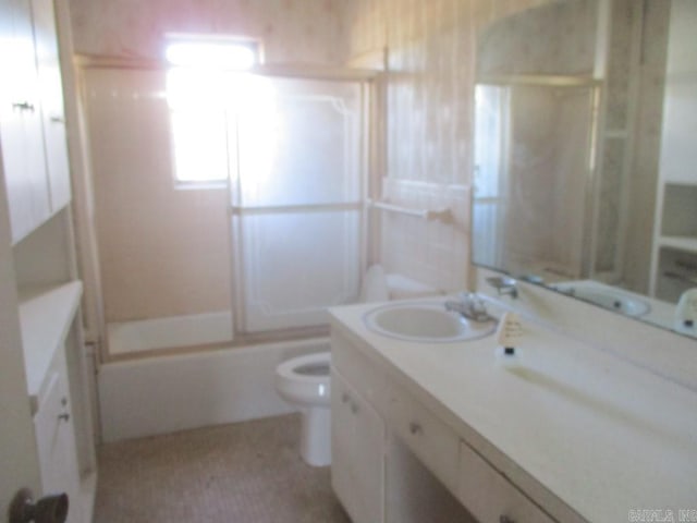 bathroom with toilet, bath / shower combo with glass door, and vanity