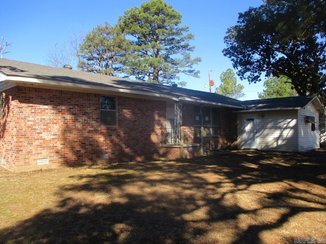 exterior space with crawl space, brick siding, and a lawn