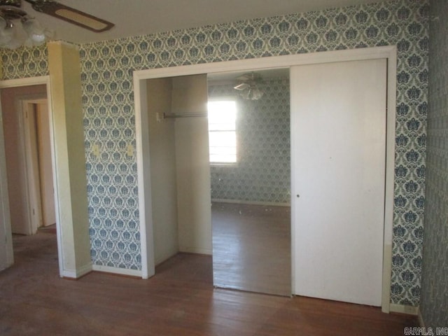 interior space with wallpapered walls, baseboards, a ceiling fan, and wood finished floors