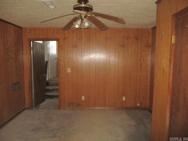 unfurnished room with wood walls and ceiling fan