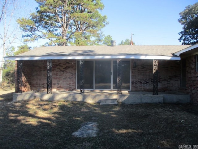 rear view of house featuring brick siding and a patio area