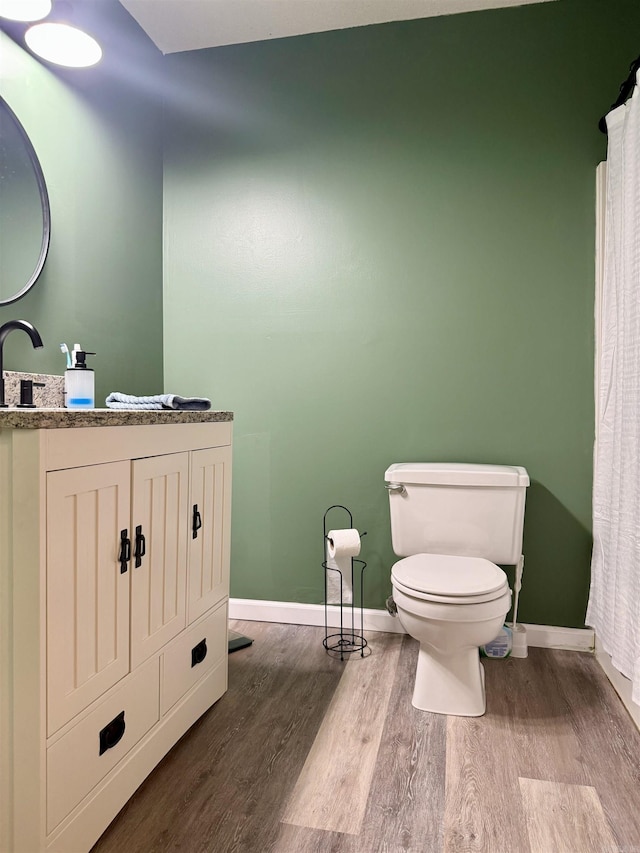 full bathroom featuring toilet, baseboards, and wood finished floors