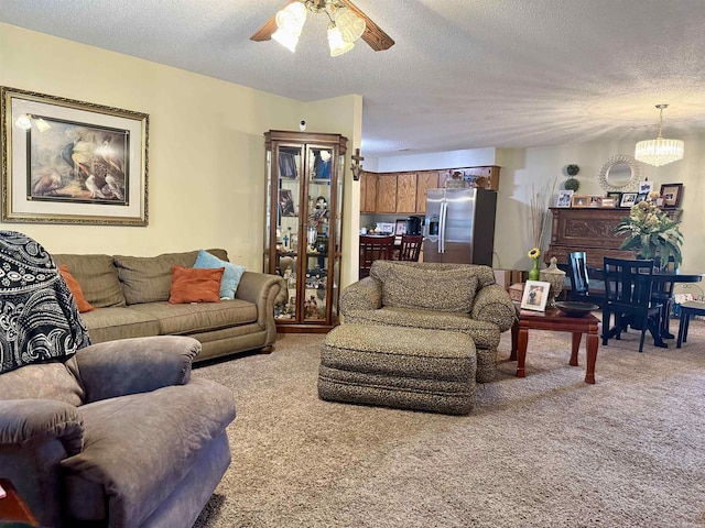 living room featuring a textured ceiling, ceiling fan with notable chandelier, and light colored carpet