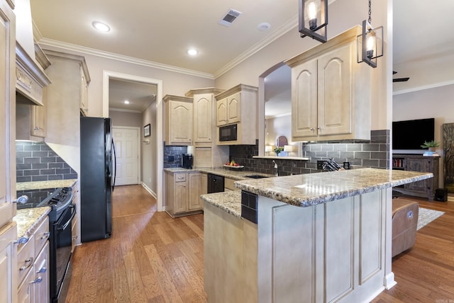 kitchen with light wood-style flooring, a peninsula, visible vents, black appliances, and light brown cabinetry