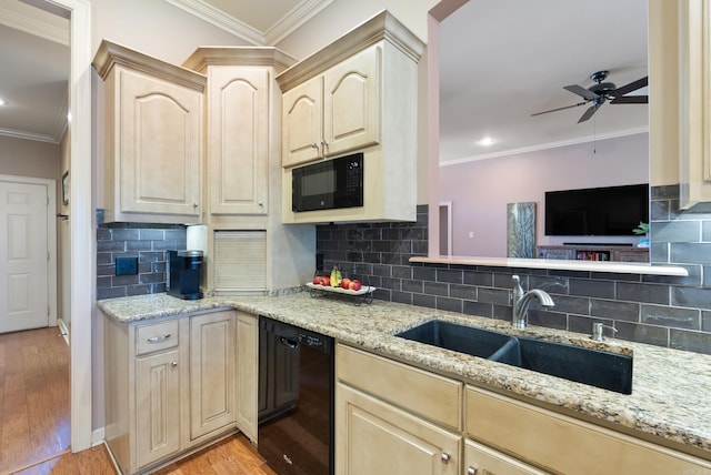 kitchen with light brown cabinets, black appliances, light wood-type flooring, and a sink