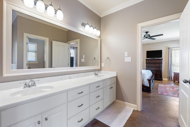 full bath with double vanity, crown molding, and a sink