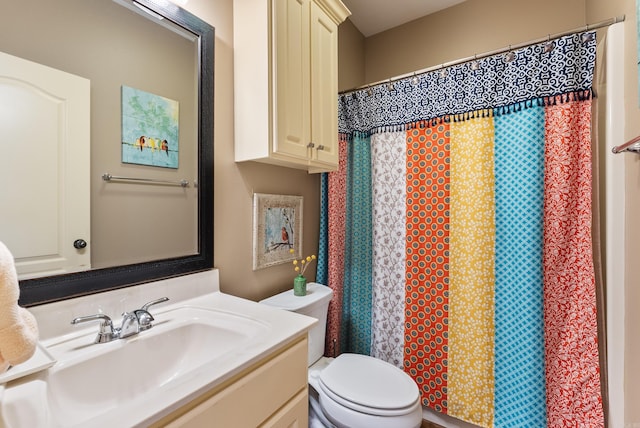 full bathroom featuring a shower with shower curtain, vanity, and toilet