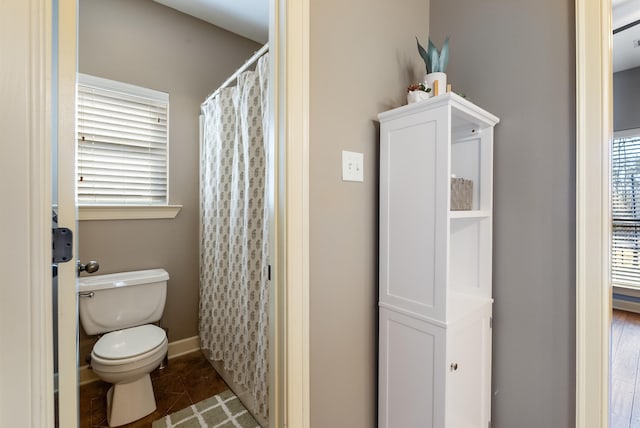 full bathroom with toilet, a shower with curtain, baseboards, and tile patterned floors