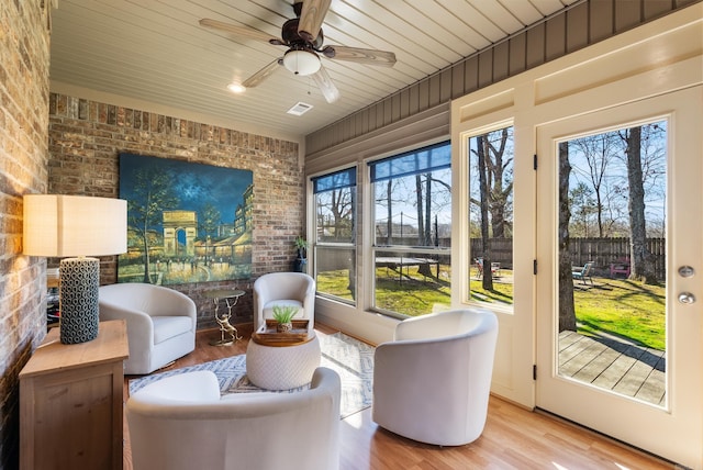 sunroom / solarium featuring visible vents, wooden ceiling, and a ceiling fan