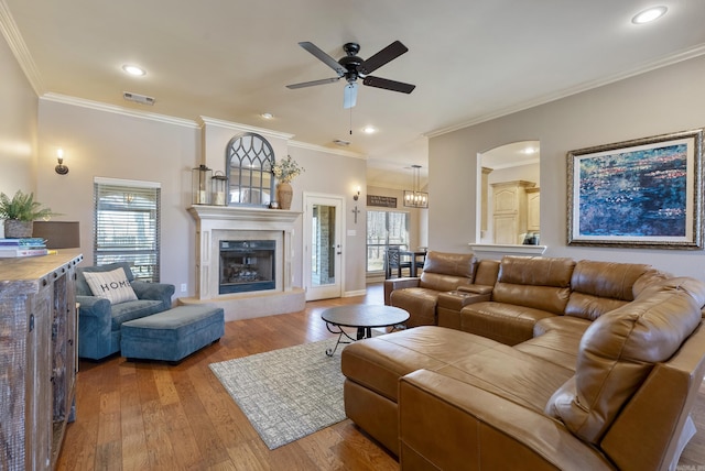 living area with visible vents, a glass covered fireplace, ceiling fan, hardwood / wood-style floors, and recessed lighting