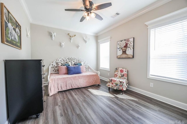 bedroom featuring wood finished floors, visible vents, and crown molding