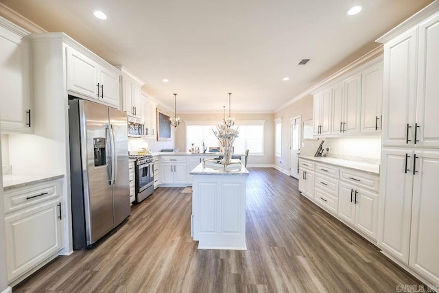 kitchen with a notable chandelier, dark wood-type flooring, white cabinetry, appliances with stainless steel finishes, and an island with sink