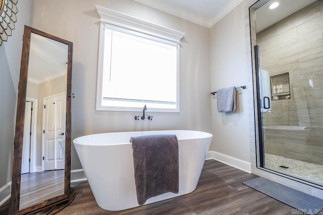 bathroom featuring ornamental molding, a stall shower, baseboards, and wood finished floors