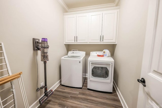 laundry room with dark wood-type flooring, cabinet space, washer and clothes dryer, and baseboards