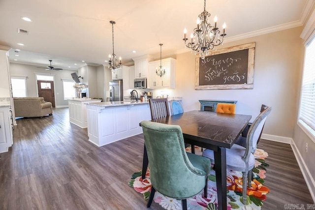 dining space with baseboards, dark wood finished floors, visible vents, and crown molding