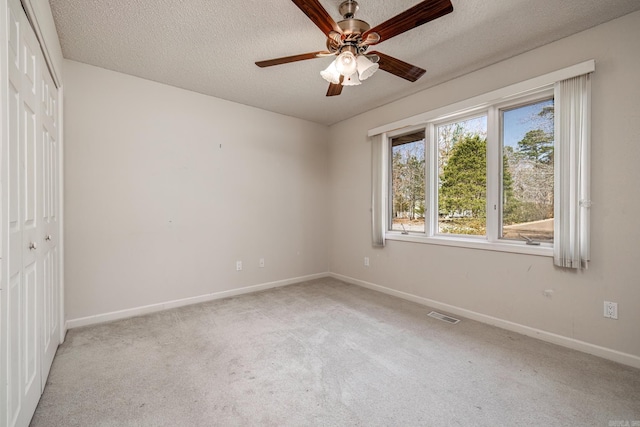 unfurnished bedroom featuring carpet, a closet, visible vents, a textured ceiling, and baseboards