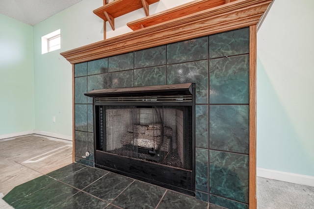 details with a tile fireplace and baseboards