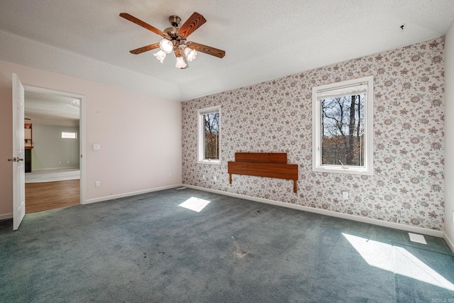 empty room featuring carpet floors, a textured ceiling, and wallpapered walls