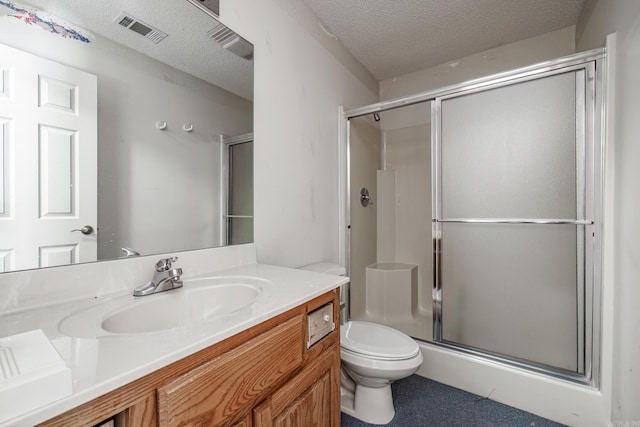 bathroom with visible vents, toilet, a shower stall, a textured ceiling, and vanity