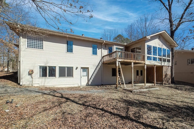 back of property with a sunroom and a deck