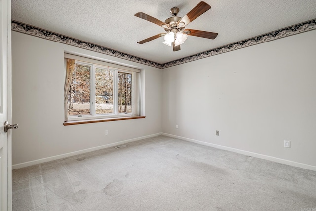 unfurnished room with light carpet, a textured ceiling, and baseboards