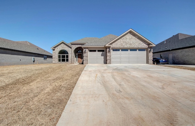 view of front of property with an attached garage, a shingled roof, concrete driveway, and brick siding