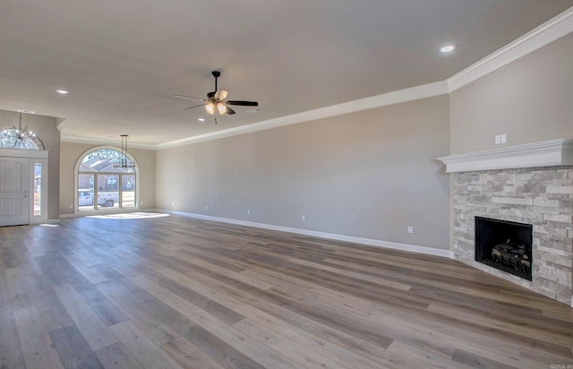 unfurnished living room featuring a fireplace, baseboards, and wood finished floors