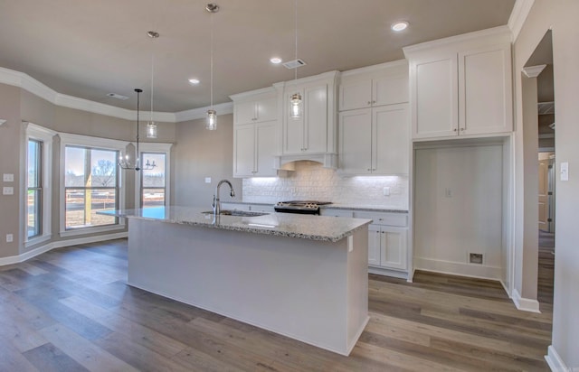 kitchen with visible vents, backsplash, ornamental molding, white cabinetry, and a sink