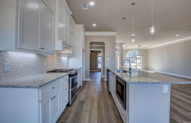 kitchen with stainless steel appliances, ornamental molding, a sink, and decorative backsplash