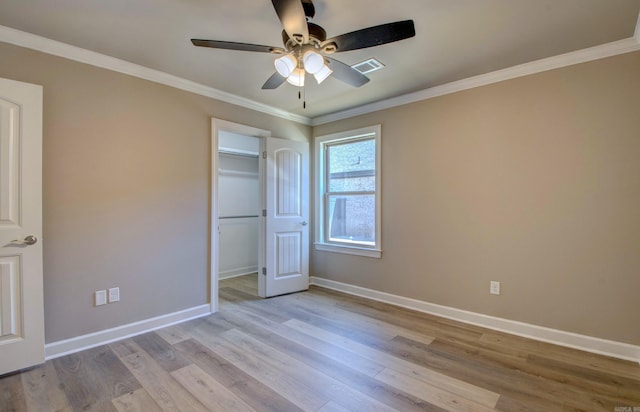 unfurnished bedroom with light wood-style flooring, visible vents, baseboards, and ornamental molding