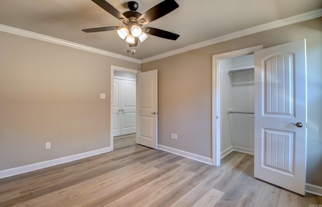 unfurnished bedroom featuring baseboards, a ceiling fan, crown molding, light wood-type flooring, and a closet