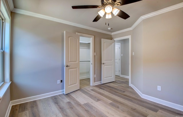 unfurnished bedroom featuring ornamental molding, ceiling fan, light wood-style flooring, and baseboards