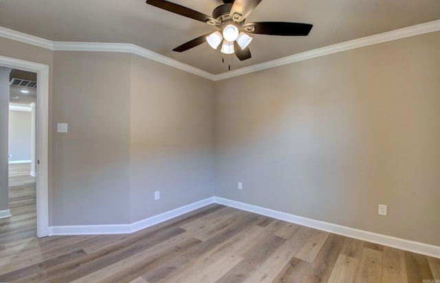 spare room featuring visible vents, baseboards, ceiling fan, ornamental molding, and wood finished floors