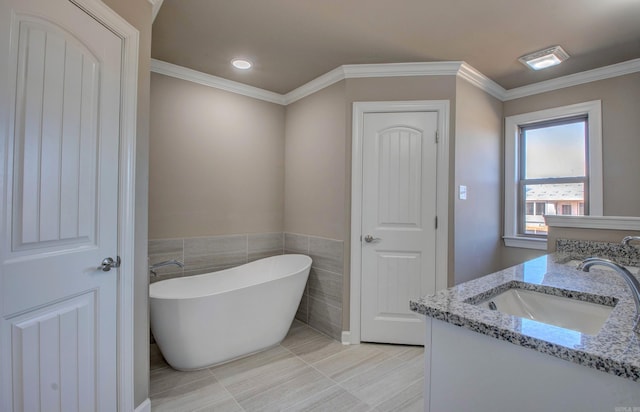 bathroom featuring double vanity, a soaking tub, ornamental molding, and a sink