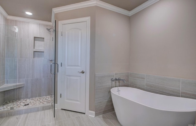 full bathroom featuring recessed lighting, tile walls, a freestanding bath, a stall shower, and crown molding